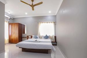 a bedroom with a bed and a ceiling fan at Hotel Gateway Suites Bangalore Airport in Yelahanka