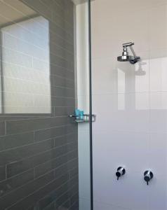 a shower with a glass door in a bathroom at The Bexley Motel in Sydney