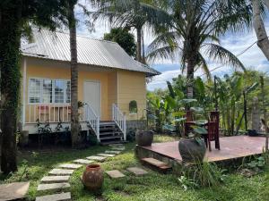 a small yellow house with a porch and palm trees at Tropical Garden Phu Quoc in Phu Quoc