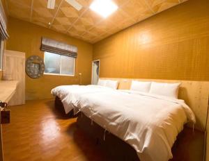 um quarto com uma grande cama branca num quarto em 山旅民宿 em Meishan
