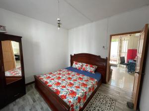 a bedroom with a bed with a floral bedspread at Green bay 2 in Pereybere