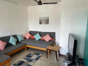 a living room with a couch and a tv at Green Bay Villa in Pereybere