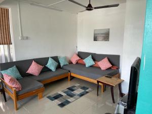a living room with a couch with colorful pillows at Green Bay Villa in Pereybere