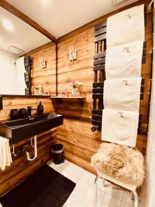 a bathroom with wooden walls and a sink and towels at Wilderer Suiten Mariazell in Mariazell