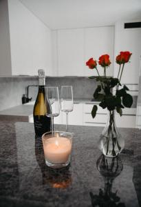 a bottle of wine and two glasses and a candle on a table at Apartman PENNY in Zvolen