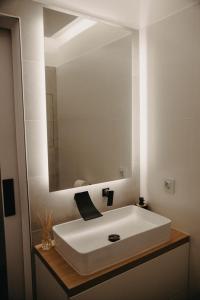 a bathroom with a white sink and a mirror at Apartman PENNY in Zvolen