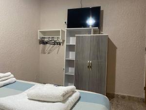Habitación con armario, TV y toallas. en Departamentos - del TALAMPAYA en Villa Unión