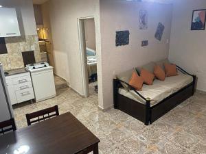 Habitación con sofá, mesa y cocina. en Departamentos - del TALAMPAYA en Villa Unión