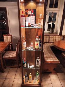 Hotel Weinhof Groß Mackenstedt في ستوهر: رف به زجاجات من الكحول في مطعم
