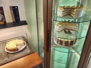 einen Kühlschrank mit drei Stufen Kuchen darin in der Unterkunft Hotel Weinhof Groß Mackenstedt in Stuhr