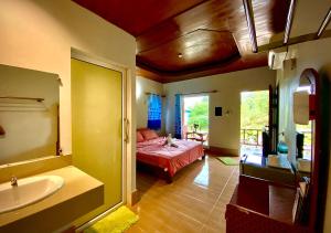 - une chambre avec un lit, une baignoire et un lavabo dans l'établissement Kohchang FuengFah, à Ko Chang