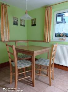 een houten tafel en 2 stoelen in een keuken bij Michel's Ferienwohnung in Kurort Gohrisch