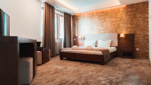 Habitación de hotel con cama y pared de ladrillo en Hotel Yesterday en Bucarest