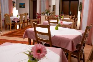 un restaurante con mesas rosas y sillas con flores. en Pension Hotel Mariahilf, en Viena