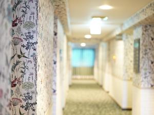 un pasillo en un hospital con papel pintado floral en Hotel AreaOne Takamatsu City, en Takamatsu