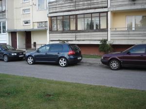 três carros estacionados num parque de estacionamento em frente a um edifício em Siguldas Street Apartment in Ventspils em Ventspils