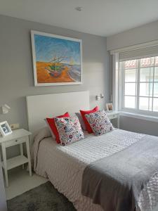 a bedroom with a bed and a painting on the wall at ESTUDIO EN BAIONA- PLAYA SANTA MARTA in Baiona