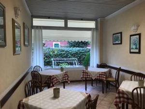 een restaurant met tafels en stoelen en een groot raam bij Hotel B&B Giardino delle Rose Bike&Breakfast in Finale Ligure