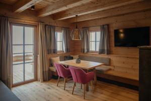 a dining room with a table and chairs and a television at Hygna Chalets in Reith im Alpbachtal