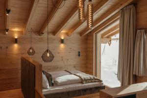 a bedroom with a bed in a wooden wall at Hygna Chalets in Reith im Alpbachtal +109 photos