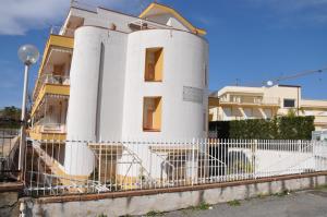 un edificio blanco con una valla delante en Taormina Mare Appartamento 300 Metri dal Mare, en Giardini Naxos