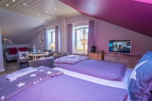 a purple bedroom with two beds and a table at Frau Holle in Westerland (Sylt)