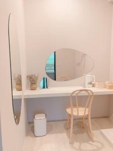 a white bathroom with a mirror and a chair at 如沐咖啡旅宿 in Xingjian +40 photos