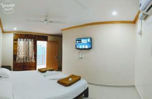 Zimmer mit 2 Betten und einem TV an der Wand in der Unterkunft ORANGE SKY INN HOLIDAY HOME in Canacona