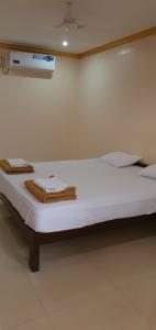 a white bed in a room with avertisement at ORANGE SKY INN HOLIDAY HOME in Canacona