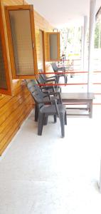 ORANGE SKY INN HOLIDAY HOME في محطة كاناكونا: مجموعة من الكراسي على الشرفة