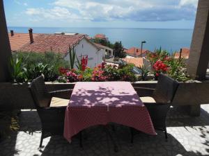 a table and chairs on a patio with a view of the ocean at Apartments Grloman in Sveti Stefan