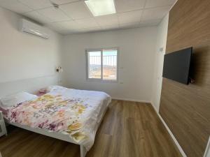 une chambre blanche avec un lit et une fenêtre dans l'établissement צימר סוד החרמון, à Majdal Shams