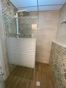 une douche avec une porte vitrée dans une salle de bain dans l'établissement צימר סוד החרמון, à Majdal Shams