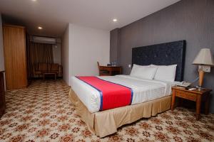 a hotel room with a large bed and a desk at Hotel The Enchanted in Dhaka