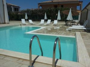 a large swimming pool with chairs and umbrellas at Archiammare Sea in San Lorenzo