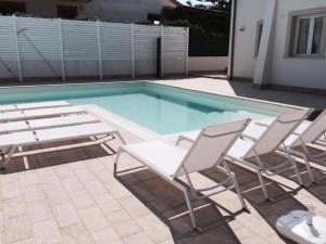 a group of chairs sitting next to a swimming pool at Archiammare Sea in San Lorenzo