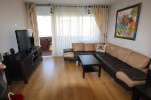 a living room with a couch and a flat screen tv at Royal Apartments , Blvd Nitza 8 in Netanya