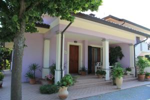 a white house with potted plants in front of it at B&B Valmarecchia in Poggio Berni