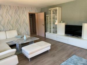a living room with a couch and a table and a tv at Ferienwohnungen und Gästezimmer Herrmann in Steinbach am Wald