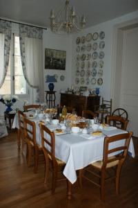 een eetkamer met een tafel en stoelen en borden aan de muur bij Chambre d'hôte Moulin de l'Aumonier in Beaulieu-lès-Loches