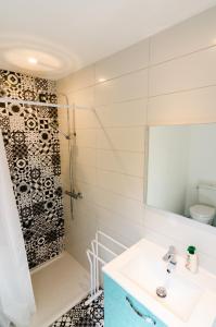 ein Badezimmer mit einem weißen Waschbecken und einer Dusche in der Unterkunft Gîte Ohlavache! in Champtoceaux