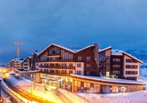 La nuit, un bâtiment est rendu dans la neige dans l'établissement The View Apartment, Terra Complex neighbour building, à Bansko