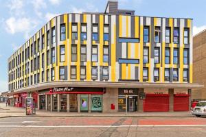 un edificio amarillo en una calle con una tienda en Park Street Apartment Luton by Hostaguest, en Luton