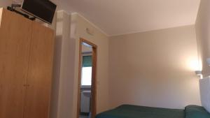 Habitación con cama y TV en la pared. en Andreoli & Miglioranzi, en San Giovanni Lupatoto