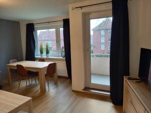 d'une salle à manger avec une table et une fenêtre. dans l'établissement Ems Apartment, à Emden