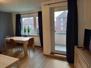 ein Esszimmer mit einem Tisch und einem Fenster in der Unterkunft Ems Apartment in Emden