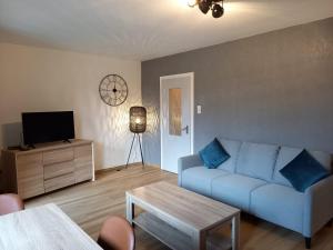 a living room with a blue couch and a table at Ems Apartment in Emden