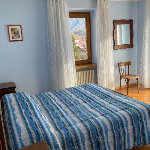 a bedroom with a bed and a window and a chair at Casa Stefani in Commezzadura