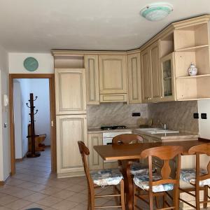 a kitchen with wooden cabinets and a table and chairs at Casa Stefani in Commezzadura