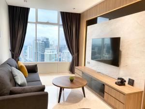 クアラルンプールにあるSky Suites KLCC by GENESISのソファと薄型テレビのあるリビングルーム